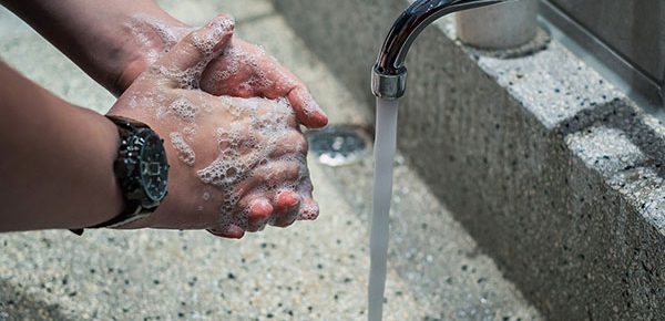 a person washing their hands with soap and water
