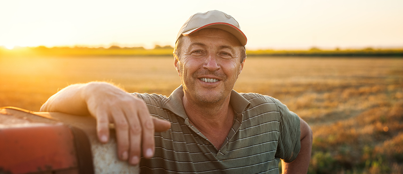 farmer smiling in front of a field