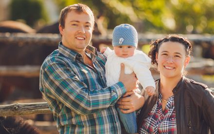 parents with their baby on a farm