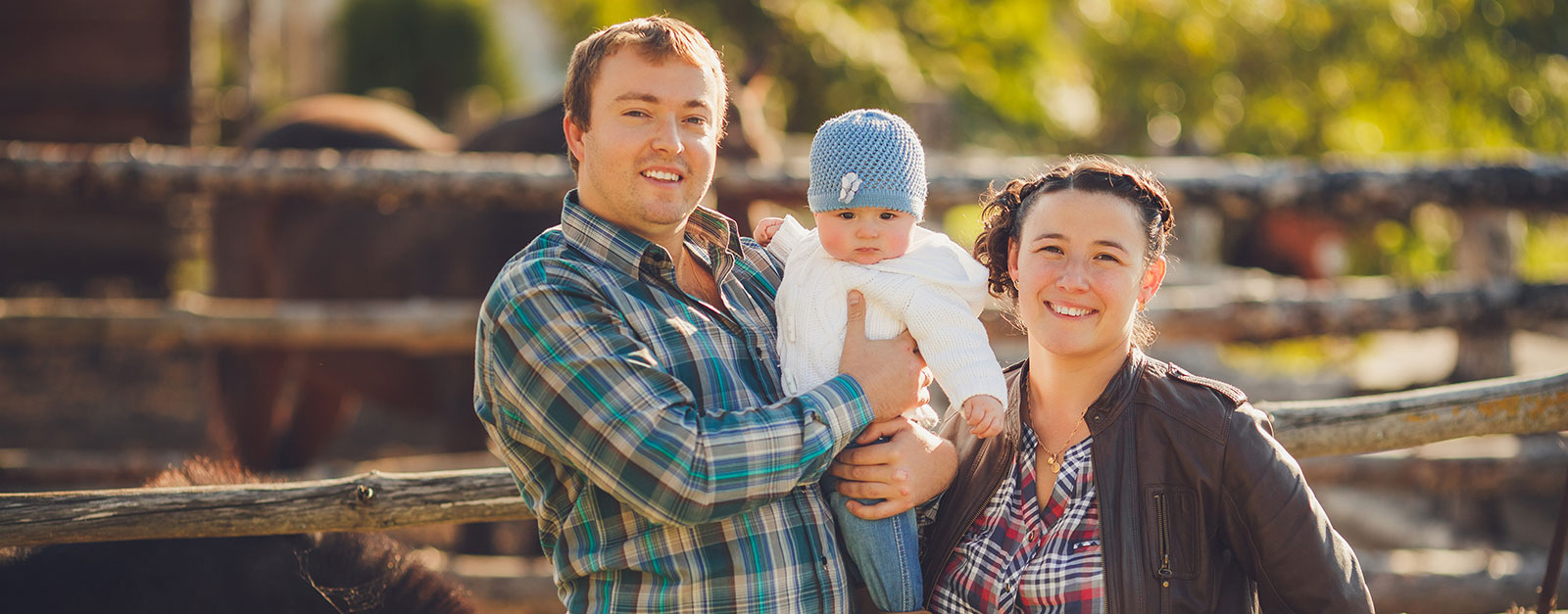 parents with their baby on a farm