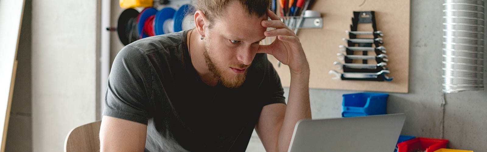 a stressed man looking at a computer in his work room