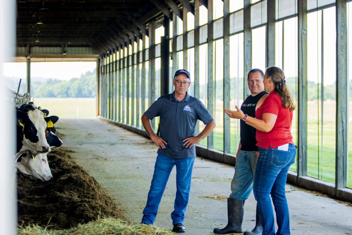 Three people talking in a barn