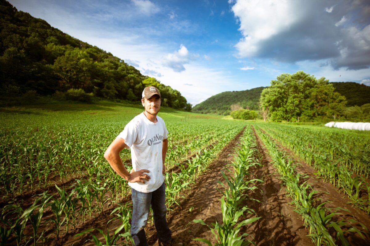 A man standing proudly in front of his field