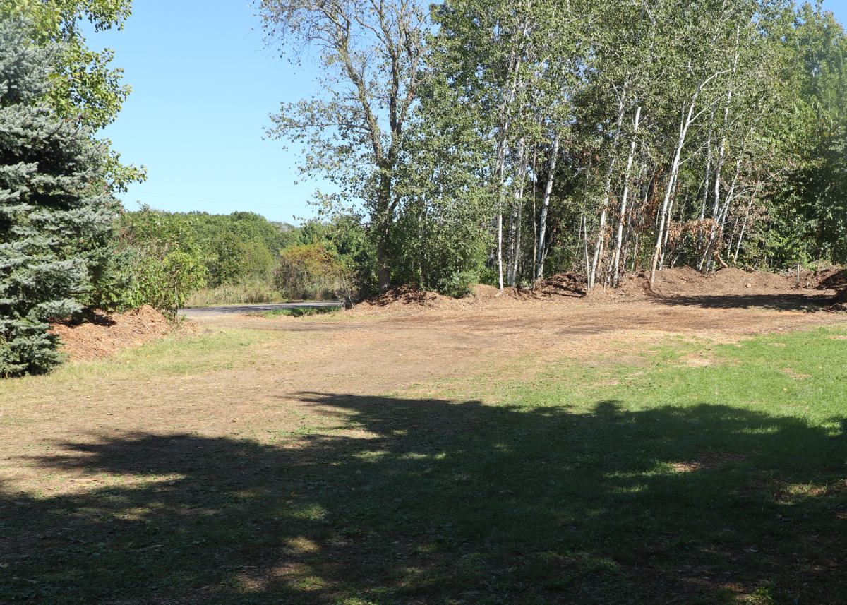 A grass and gravel parking area with an even surface clear of debris.