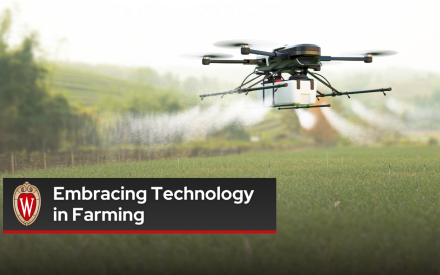 A drone applying pesticide/fertilizer above crops on a field